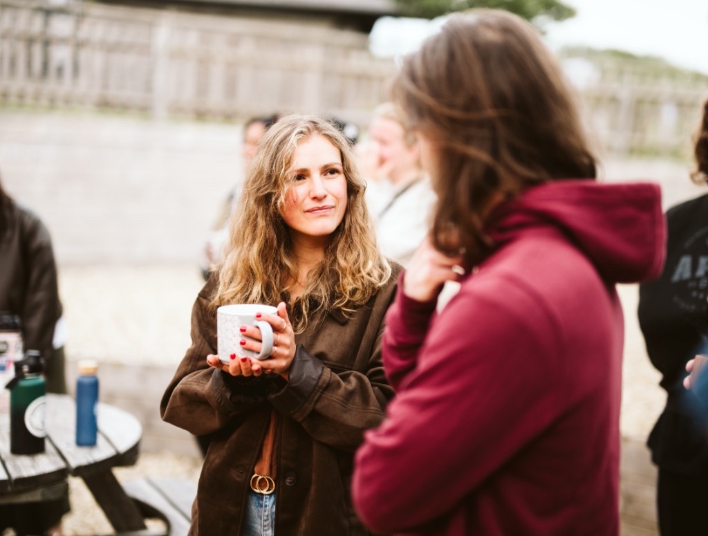 Esther in conversation over a warm drink