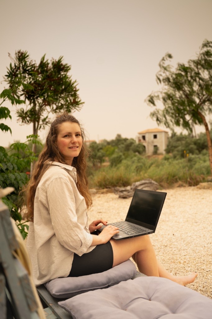 Esther working outdoors with her laptop